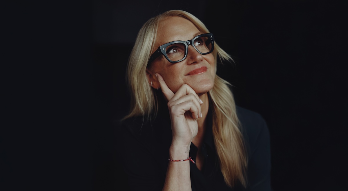 Mel Robbins pensive looking up on black background