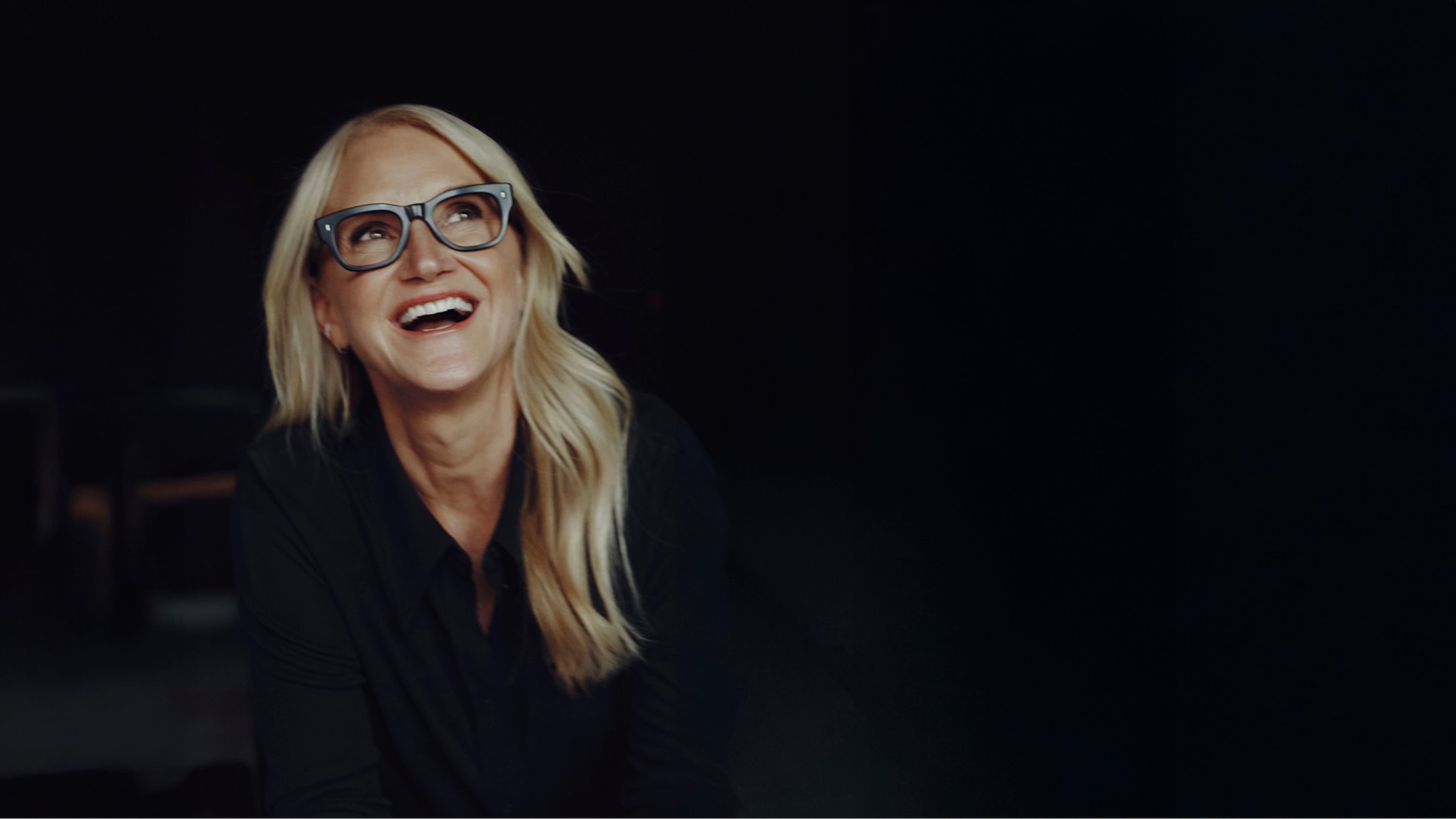 Mel Robbins smiling on black background